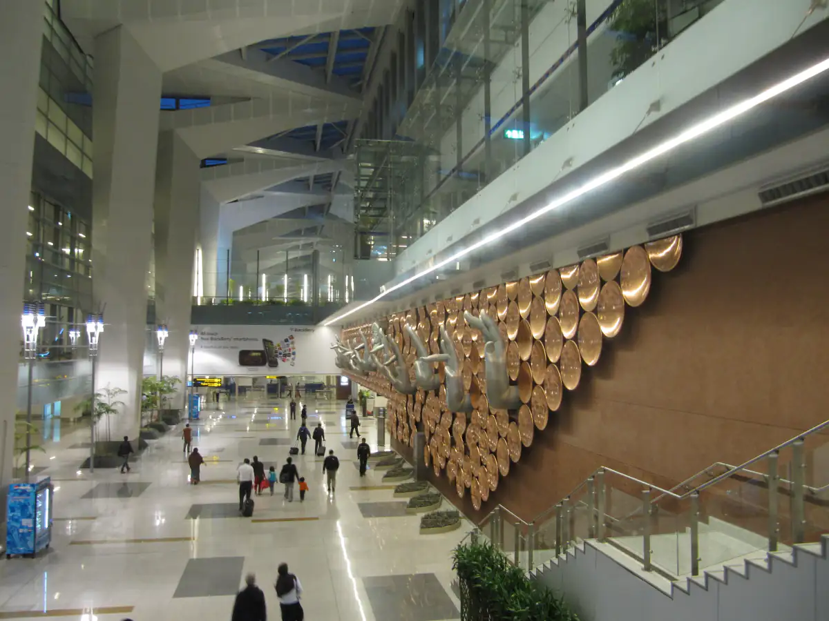 Inside Delhi T3, with the copper hasta mudra sculpture wall above the check-in hall