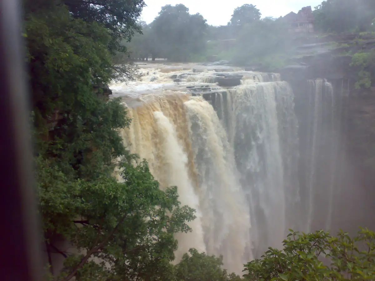 Menal waterfall plunging into a forested gorge during the monsoon